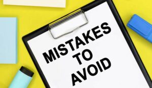 mistakes to avoid is written on a white sheet of paper that lies on a colored background among stationery