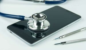 Stethoscope on the smartphone on a grey background