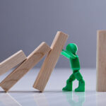 Green Human Figure Stopping Wooden Dominos Blocks