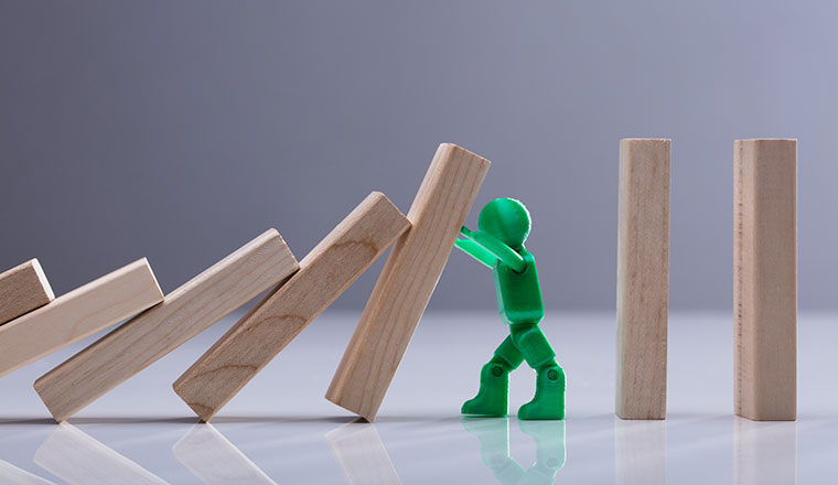 Green Human Figure Stopping Wooden Dominos Blocks