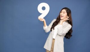 Person holding number nine and being happy