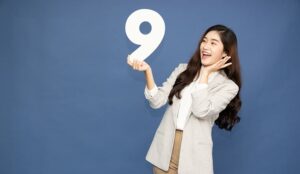 Person holding number nine and being happy