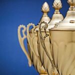 Receding staggered row of three gold trophy cups