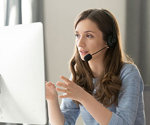 Serious call center operator in wireless headset talking with customer