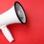 Electronic megaphone on red background