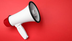 Electronic megaphone on red background