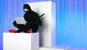 ninja in black clothing using laptop while sitting on white block with code