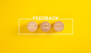 Customer feedback and satisfaction conceptual image - happy, sad and neutral faces over yellow background