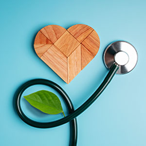 Health care concept with stethoscope and wooden heart on blue background