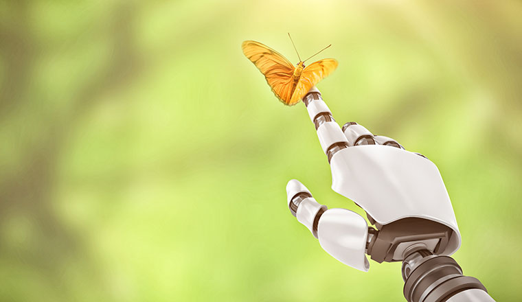 Close up of butterfly and robot hand against green background