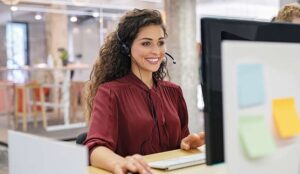 Customer support phone operator working at computer.