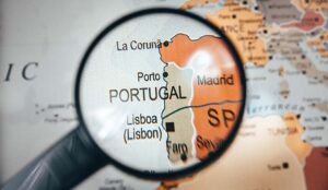 Portugal country map in focus on world map through a black color magnify glass