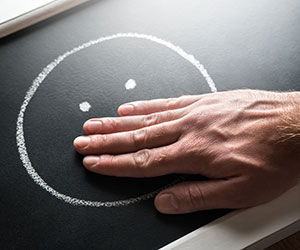 Hand covering mouth drawn on chalkboard,