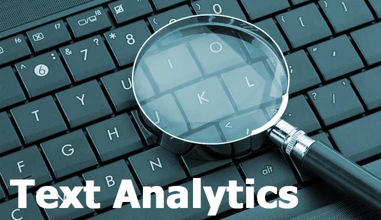 Magnifying glass on laptop with the words text analytics