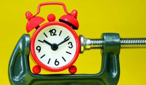 A red alarm clock placed in a Grey clamp