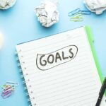 Goals text on notebook with idea on blue background