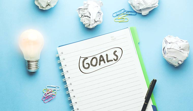 Goals text on notebook with idea on blue background
