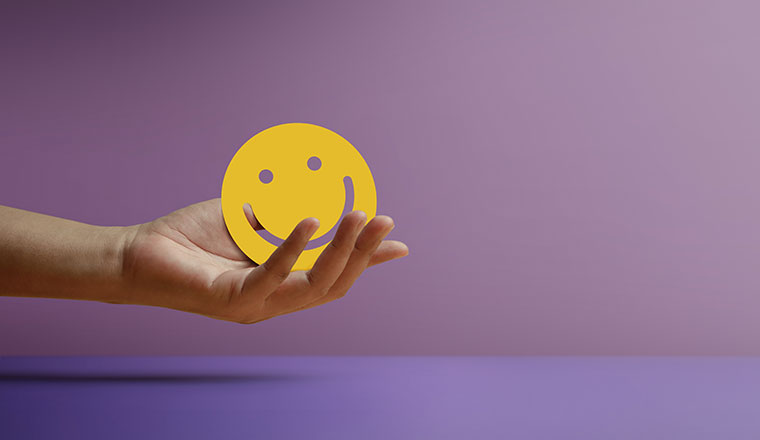 Hand Holding a Smiling Face - positive review concept