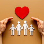 Hands holding family figure. Life and health insurance concept.
