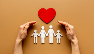 Hands holding family figure. Life and health insurance concept.