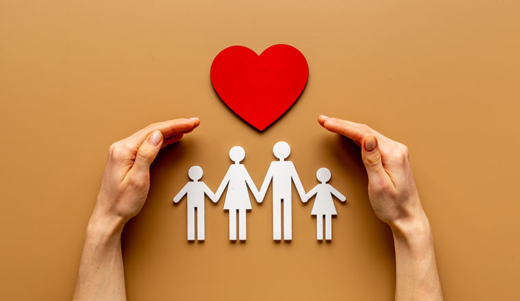 Hands holding family figure. Life and health insurance concept.