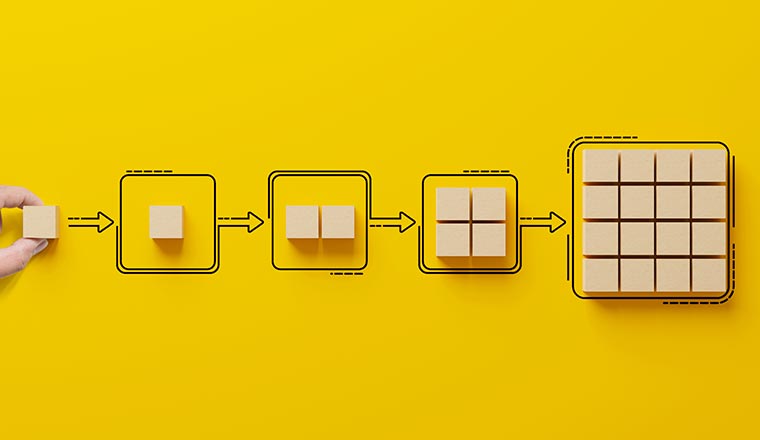 Hand holding wooden cube block arranging processing management