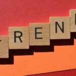Trend, word in wooden alphabet letters isolated on red and orange background