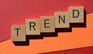 Trend, word in wooden alphabet letters isolated on red and orange background