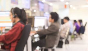 A blurred image of employees working in a call centre