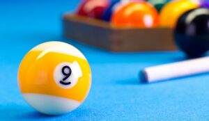 Billiard pool game nine ball with cue and nineball balls set up on billiard table