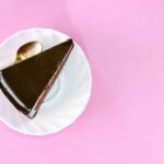 A slice of chocolate cake on pink background
