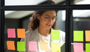 Person planning with post it notes on glass