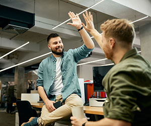 Two employees high fiving - recognising effort