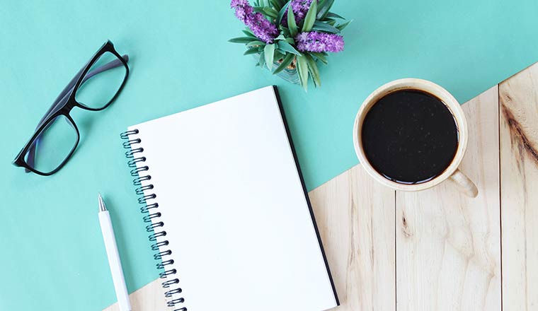 Top view image of open notebook with blank pages and coffee cup on wooden background