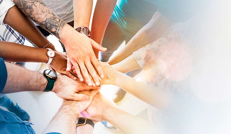 Diverse creative team stacking hands