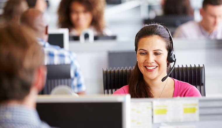 Person working in call centre, surrounded by colleagues