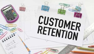 Customer retention written on paper on desk with stationary