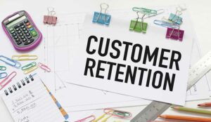 Customer retention written on paper on desk with stationary