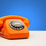 Vintage Orange Telephone On Blue Background