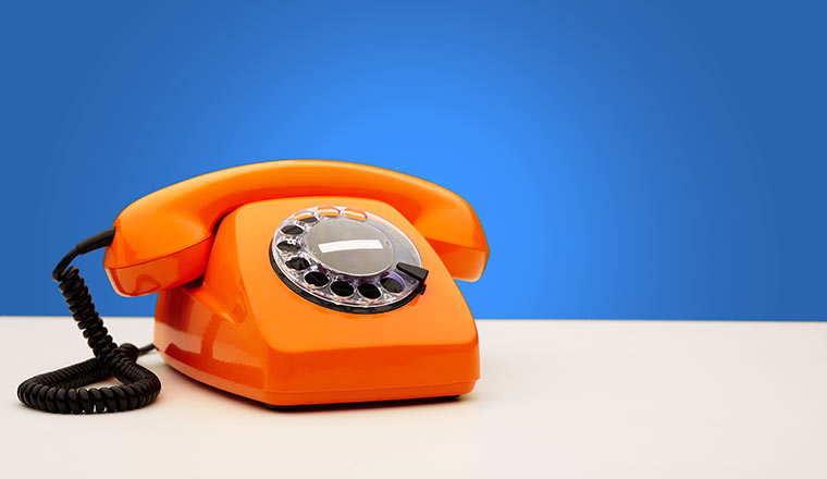 Vintage Orange Telephone On Blue Background