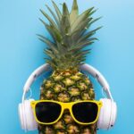A pineapple with sunglasses and headphones - fun concept