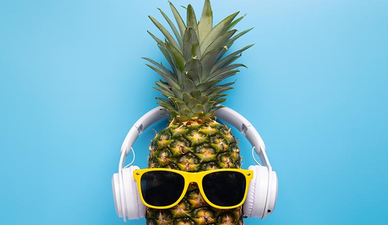 A pineapple with sunglasses and headphones - fun concept