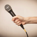 A hand holding a microphone for interview