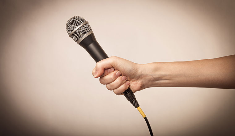 A hand holding a microphone for interview