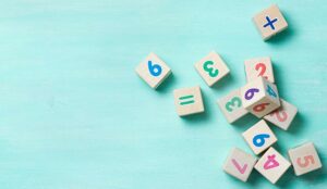 Wooden cubes with numbers on a turquoise background.