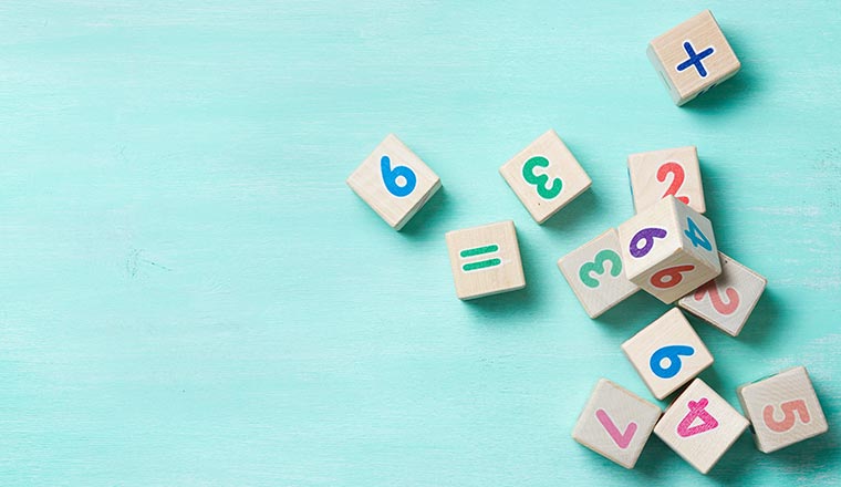 Wooden cubes with numbers on a turquoise background.