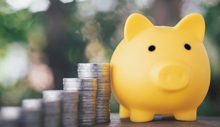 The yellow piggy bank was placed next to a pile of coins