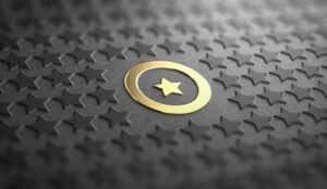 Many stars on black paper background with focus on a golden one surrounded by a circle.
