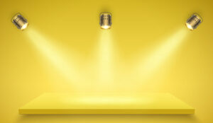 Light box with yellow platform on yellow backdrop with three spotlights. Launch and reveal concept