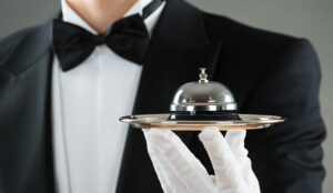 Luxury service concept with waiter holding service bell on plate